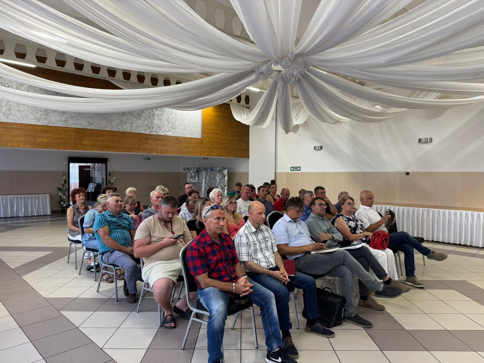 Zdjęcie przedstawia mieszkańc&oacute;w Twardowic siedzących wsp&oacute;lnie na&nbsp;zebraniu.
