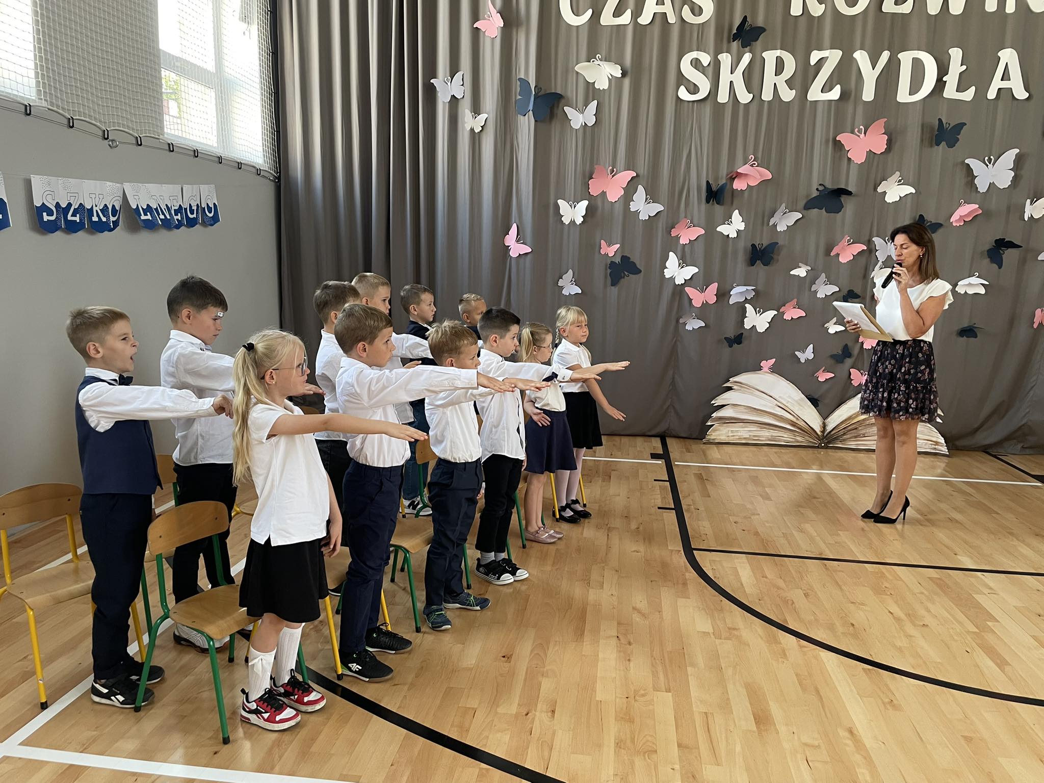 Zdjęcie przedstawia pierwszoklasist&oacute;w składających ślubowanie pierwszoklasisty. Dzieci ubrane są na&nbsp;galowo.